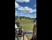 Shirtless guy rides and jumps motorcycle grass 