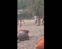 Mother in bikini makes daughter take her picture at the beach