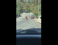 Red shirt guy jogs tripod street car