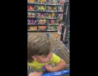 Kid sits on the pushcart gets scared with the woman with mask