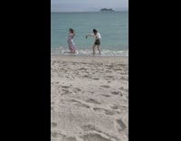 Woman violet floral dress walk spin beach