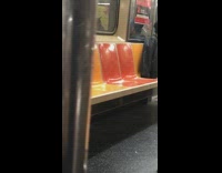 Man in black and blue hat smokes on  the subway