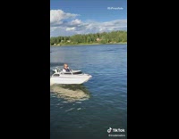 Guy drives small white half boat lake 