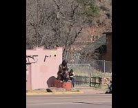 Two girls pose beside bronze woman statue