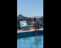 Woman takes picture of slippers beside pool