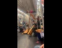 Man sings and play harp rides subway