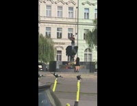 Man juggle top of lion statue fountain 