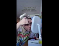 Girl white shirt picking at her face in white mirror