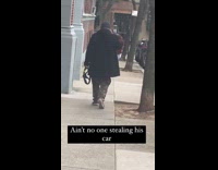 Pedestrian walks holding steering wheel 