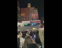 Large crowd dance and sing together 