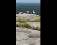 Woman white top hand foot stand mountain