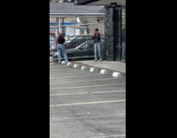 Woman poses beside the store rocky wall