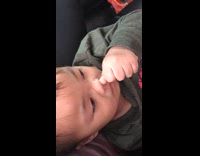 Toddler reaches and picks nose inside car