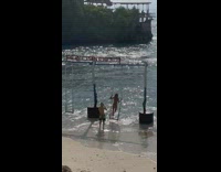 Woman in bikini stands on the swing at the beach