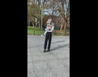 Person wears cardboard box on head and gives out flyers at the park