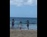 Woman in white beach dress spins by the beach