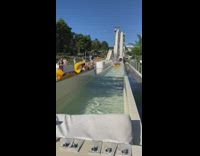 Guys on connected tube go down water slide  