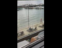 Blue jacket guy talks to phone beach 