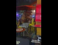 Dinosaur suit sits on restaurant patio