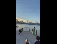 Woman performs bellydance routine for video near water 