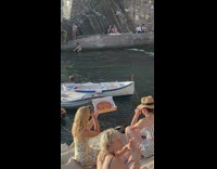 Woman take pictures pizza in box coast