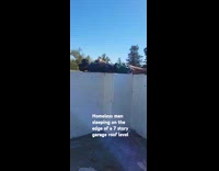 Homeless man sleeps at edge of rooftop