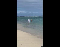 Person takes pictures of girl in ocean