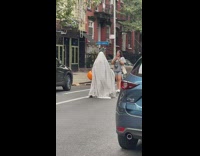 Person in a white blanket with pumpkin bucket photoshoot