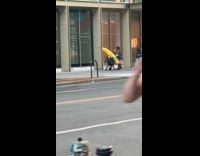 Woman walking on street with inflatable banana