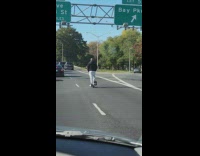 Guy rides scooter on freeway 