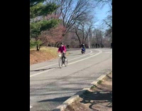 Guy standing on blue scooter does wheelie 