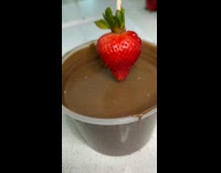 Dipping strawberry into chocolate reversed video