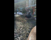 Guy reaches inside brown water fountain 