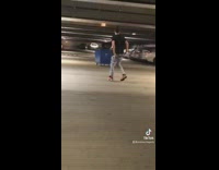 Guy pushes friend inside trash bin in parking structure and hits car
