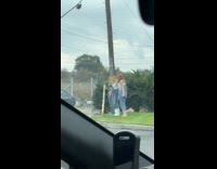 Women in overall clothes poses parking lot