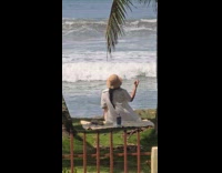 Woman films at beach with phone behind