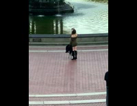 Woman in a dress poses with a tripod in front of the water fountain