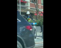 Guy holds green toy gun pedals bicycle 