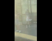 Man shirtless flexes his body at the trains station