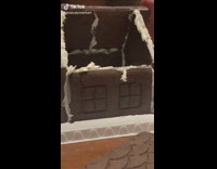 Girl makes and decorates gingerbread trap house 