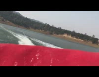 Three guys ride on inflatable ski tube in the ocean, one guy flies off