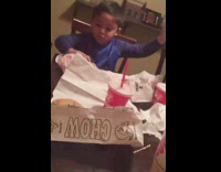 Little boy dances while eating burger