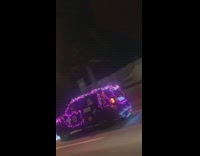Car covered in pink purple string lights 