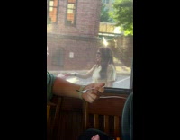 Two women dances outside the restaurant window