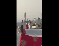 Two women same red dress photoshoot Santorini roof