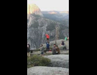 Orange jacket guy chugs beer rock mountain 