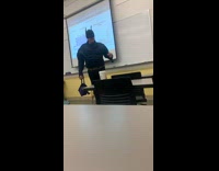Man in costume talks to class and boy jumps in and toss candy
