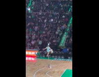 Woman in unicycle kicks bowl on to her head to balance