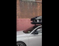 Car with giant loud speakers on top of car roof driving on the street
