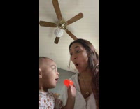 Baby puts toy into moms mouth 